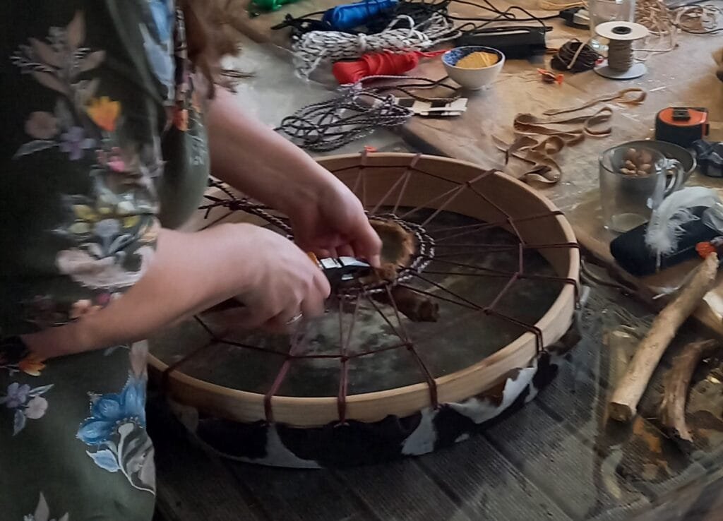 Deelnemer bouwt een sjamaandrum tijdens workshop